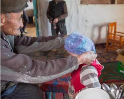 Putting knit hat on young boy