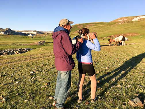Dr. P using his guide as a tripod to hold a telephoto lens still to film golden eagles