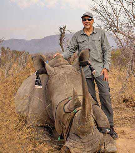 Dr. P standing next to a sedated rhino