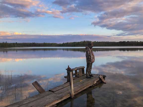Standing on dock of inland lake at sunset