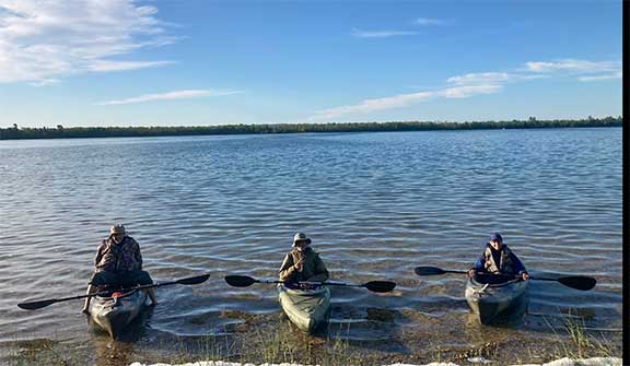 Kayakers landing on the shore of a lake