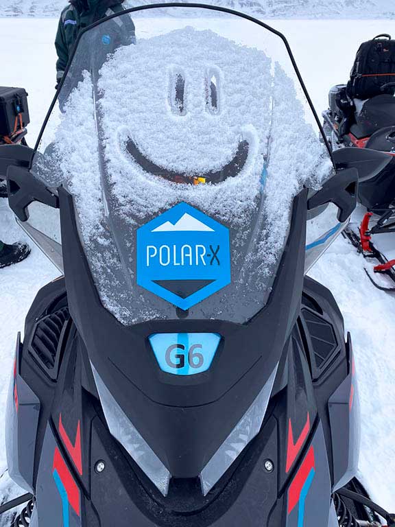 Snow on snowmobile at the start of the day.