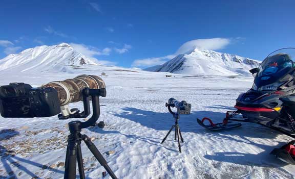 Cameras with telephoto lenses on tripods