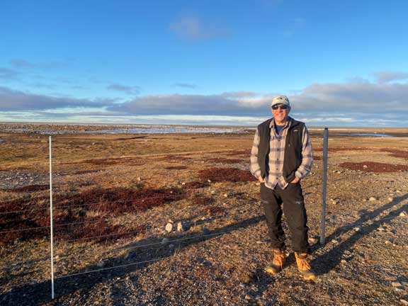 Dr. P standing at fence